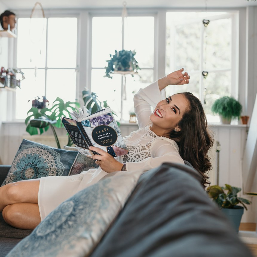 Happy woman at home reading a book